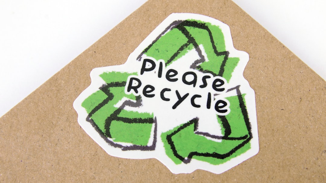 Die cut biodegradable paper sticker with please recycle logo applied to kraft paper envelope